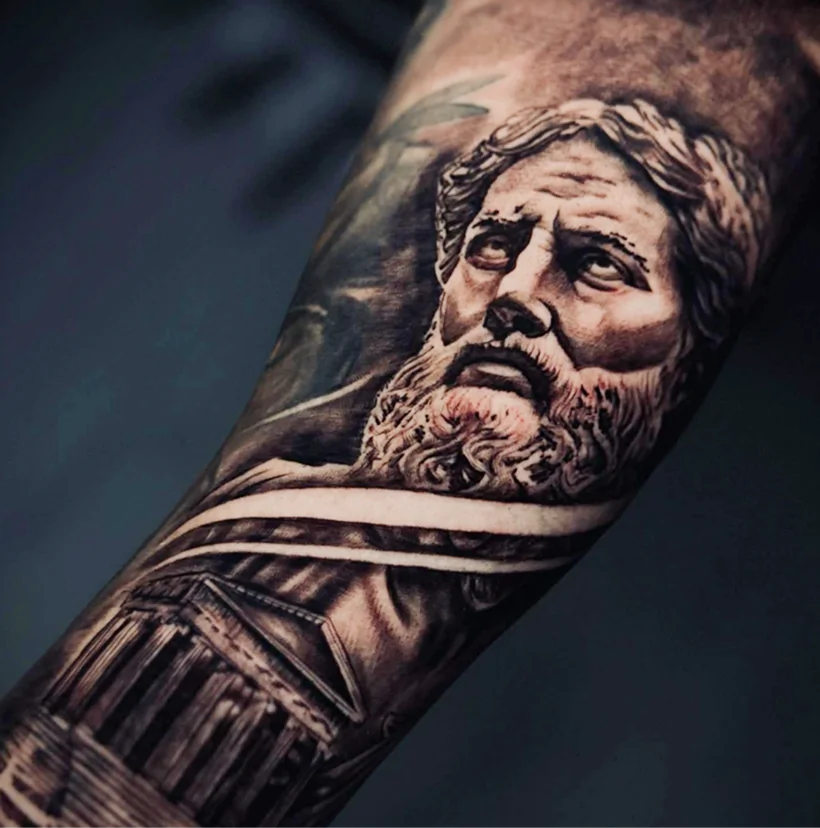 Black and grey forearm tattoo of a classical man's portrait and an ancient temple.