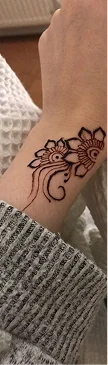Custom floral mandala henna tattoo on wrist highlighting expert temporary skin art application.