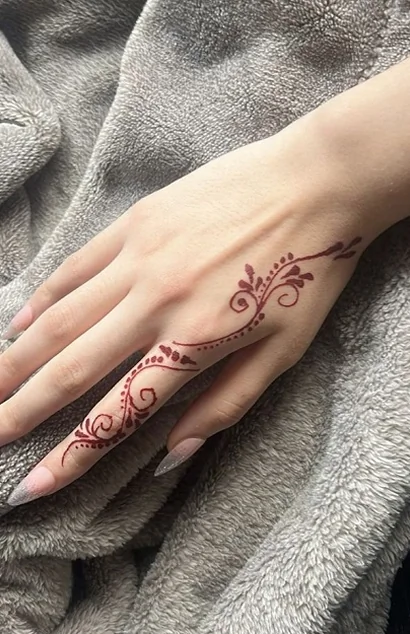 Elegant fine-line temporary henna tattoo design revealed on the back of a hand