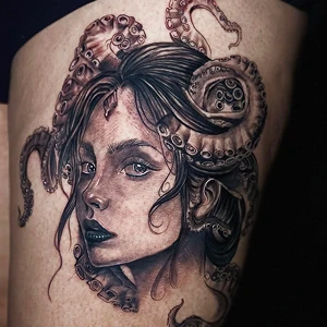 Blackwork realism tattoo on a thigh featuring a woman's portrait intertwined with octopus tentacles.